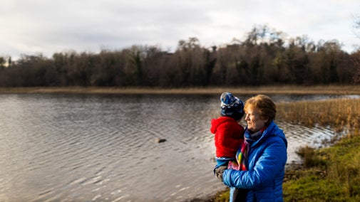 A grandmother holding her grandson looking over Lake Coole at Castle Coole